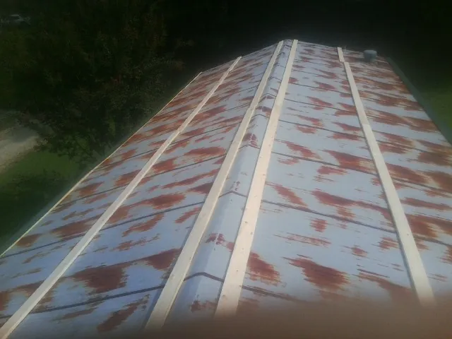 Rusted metal roof panels with new wood purlins before replacement — Storm Damage Roof Repair in Lockwood by Roofing Brothers