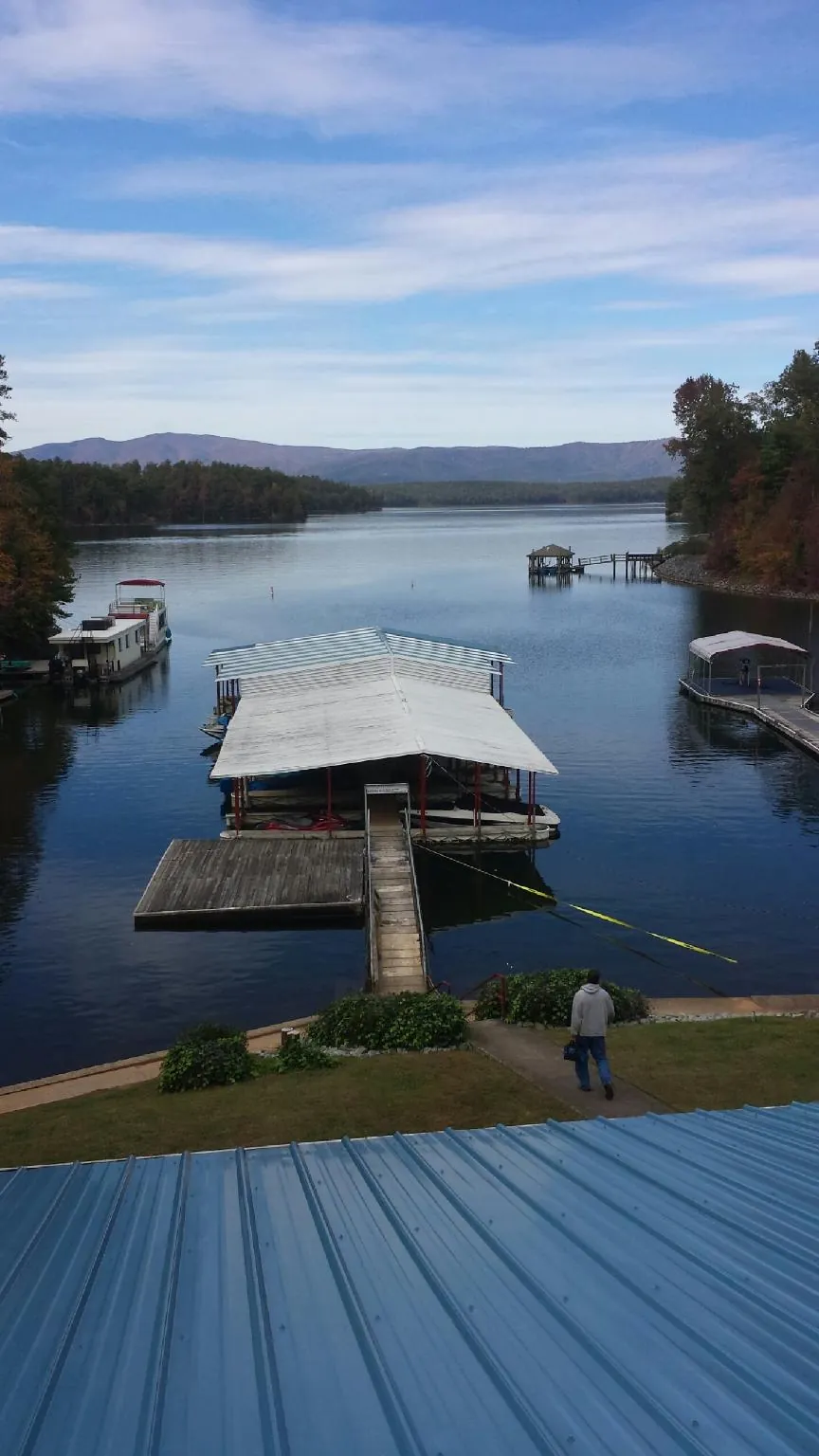 View across a lake from a newly installed blue metal roof in Lockwood